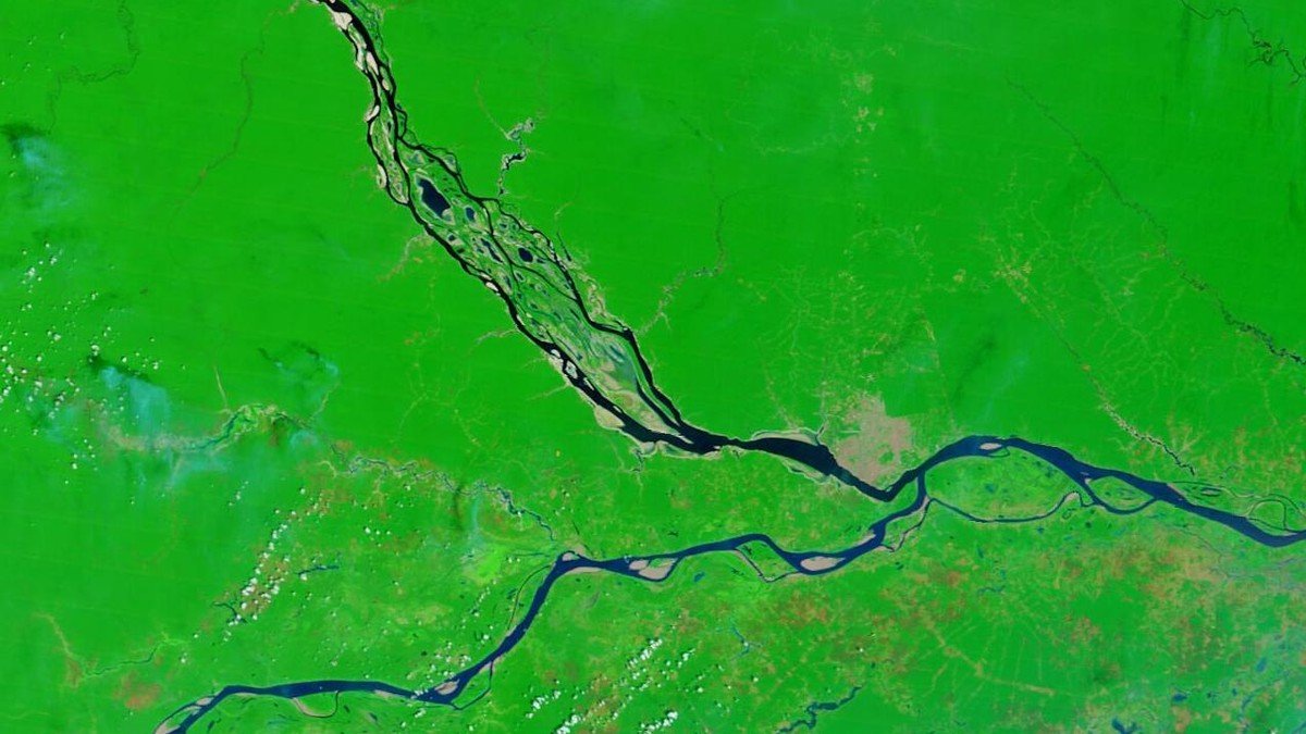 Exposed sandbars and stranded wooden riverboats on the severely receded banks of the Rio Negro
