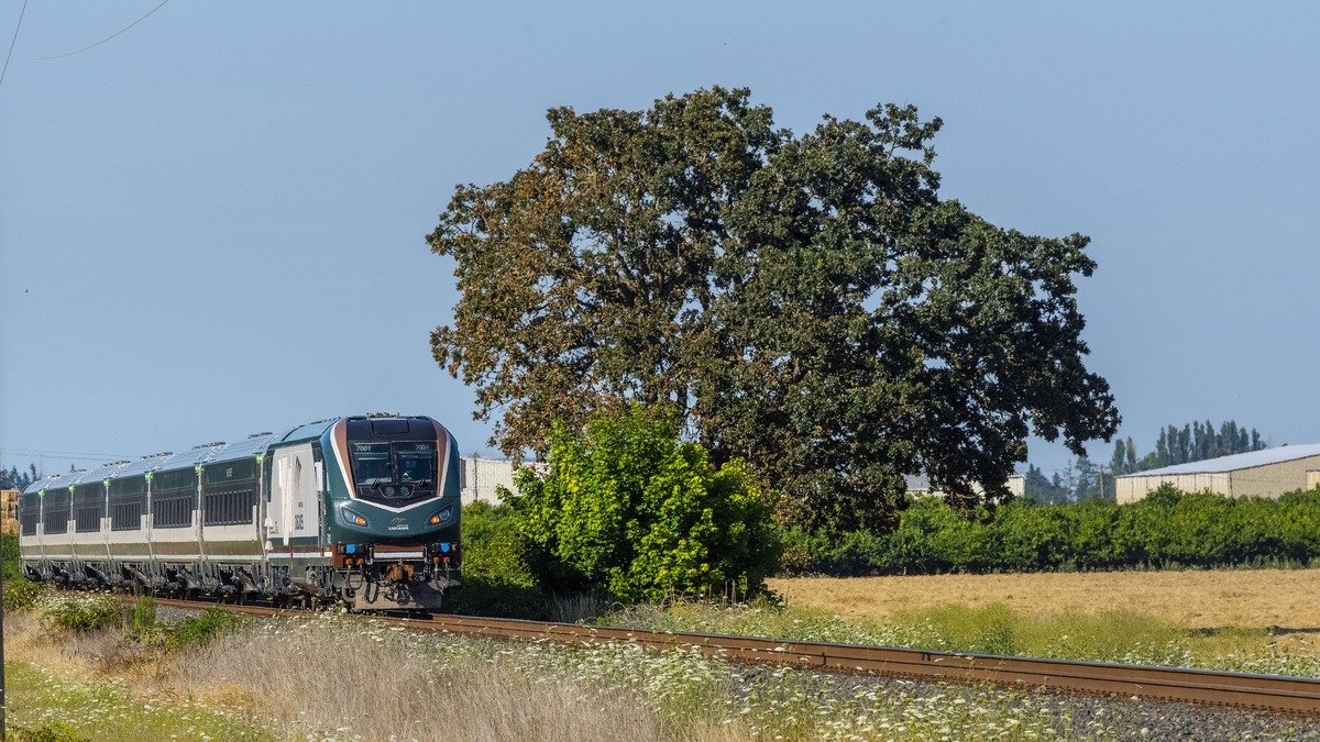 Passenger train moving along Pacific Northwest scenic coastal rail corridor