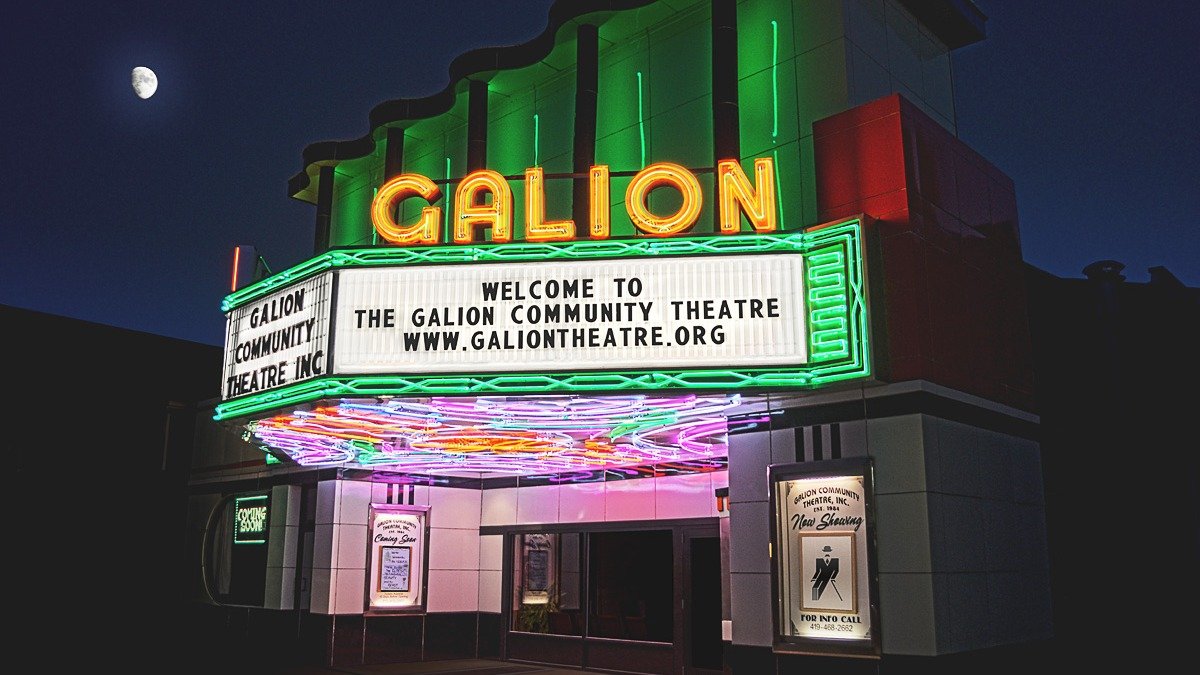 Vintage movie theater marquee illuminated with neon lights in an entertainment district