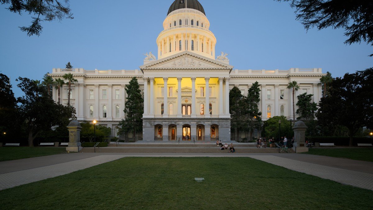 California State Capitol dome in Sacramento illuminated against evening sky