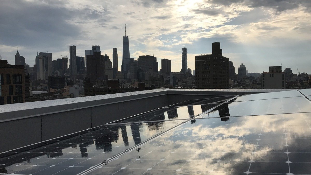 Manhattan skyline overlooking the East River with bright blue sky representing environmental progress