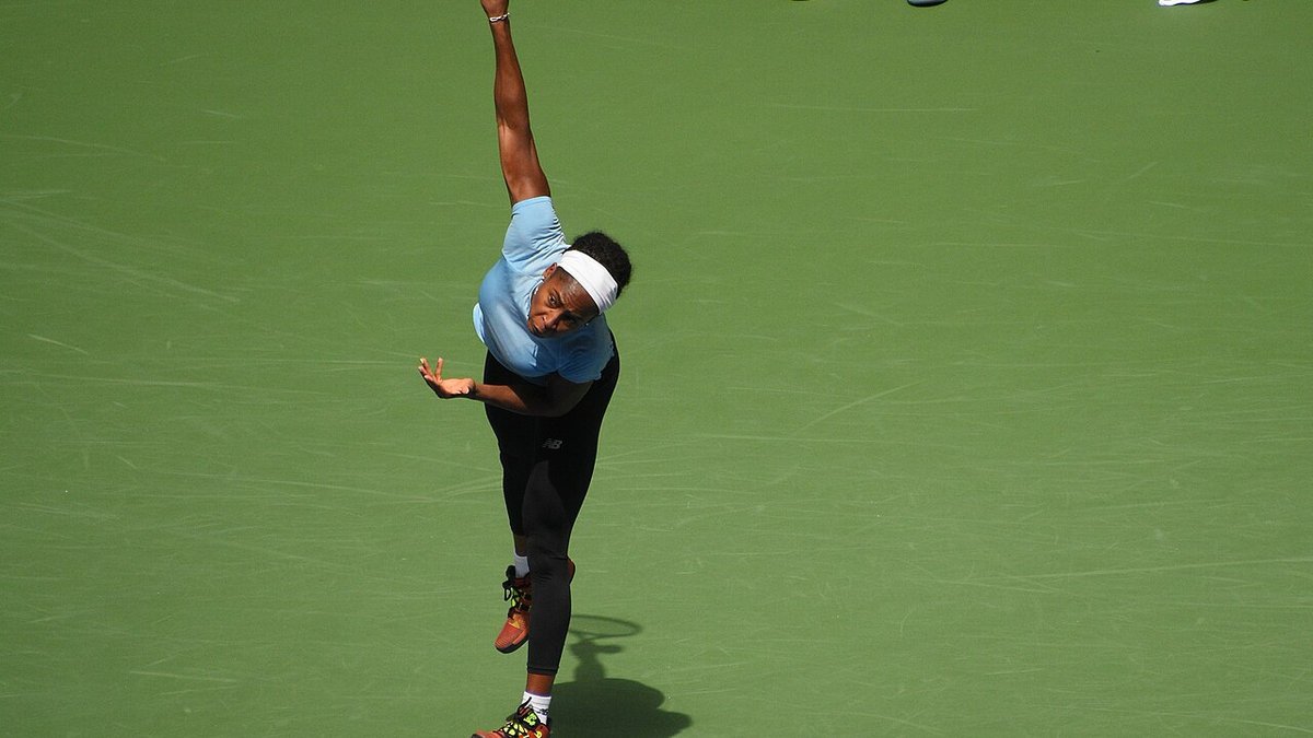 Coco Gauff holding the China Open women's singles championship trophy on court in Beijing