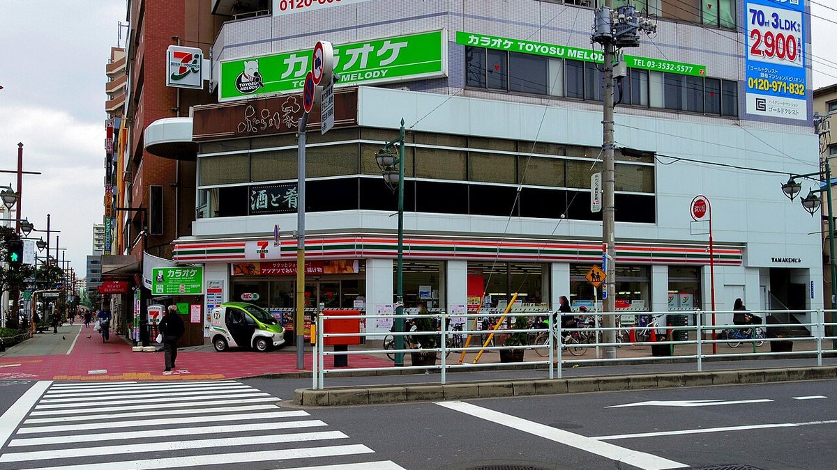 Illuminated 7-Eleven storefront sign in Tokyo with corporate retail backdrop