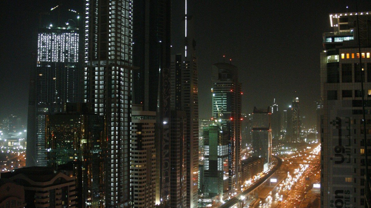 Panoramic view of the modern Dubai skyline and urban highway infrastructure under bright skies