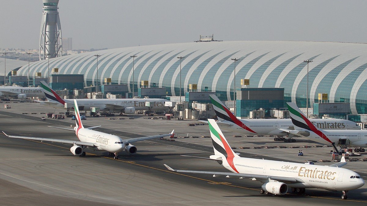 Commercial airliners parked at boarding gates at Dubai International Airport