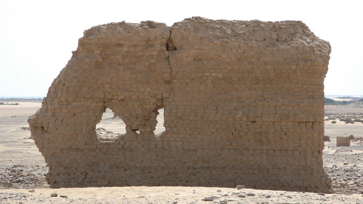 Archaeological excavation site with mudbrick ruins and ancient tomb structures in Egypt