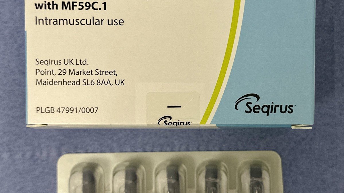 A patient holding a prefilled FluMist single-dose nasal spray influenza vaccine applicator ready for administration