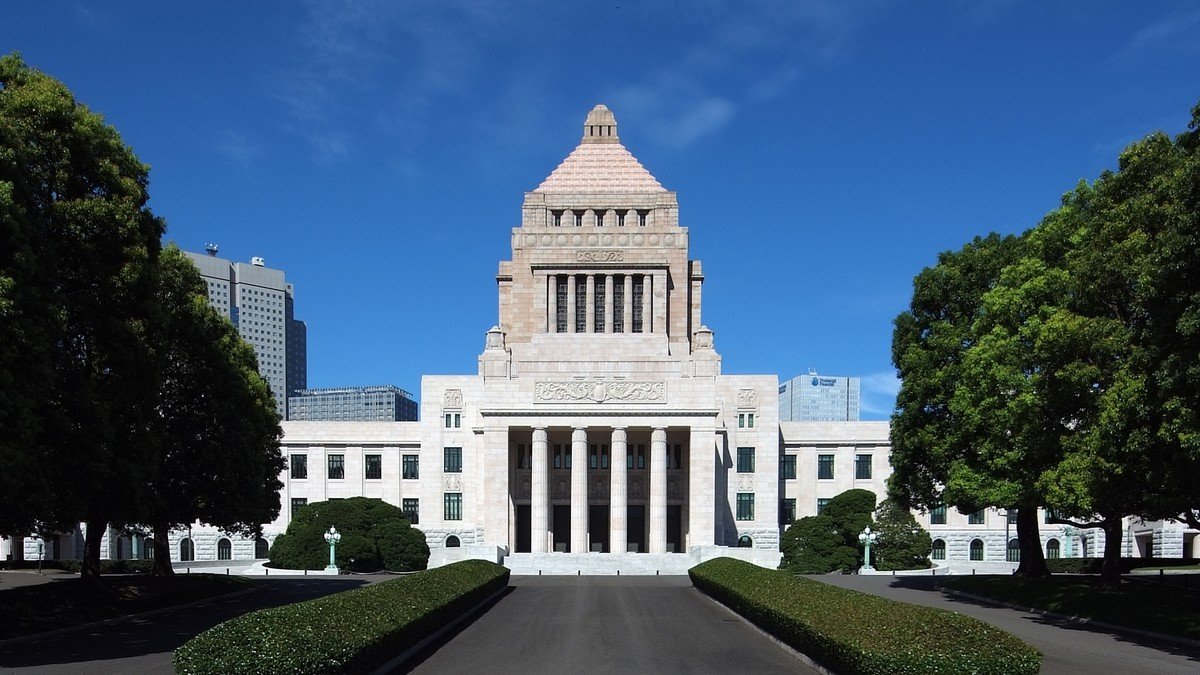 LDP leadership candidates debating on stage behind official podiums in Tokyo