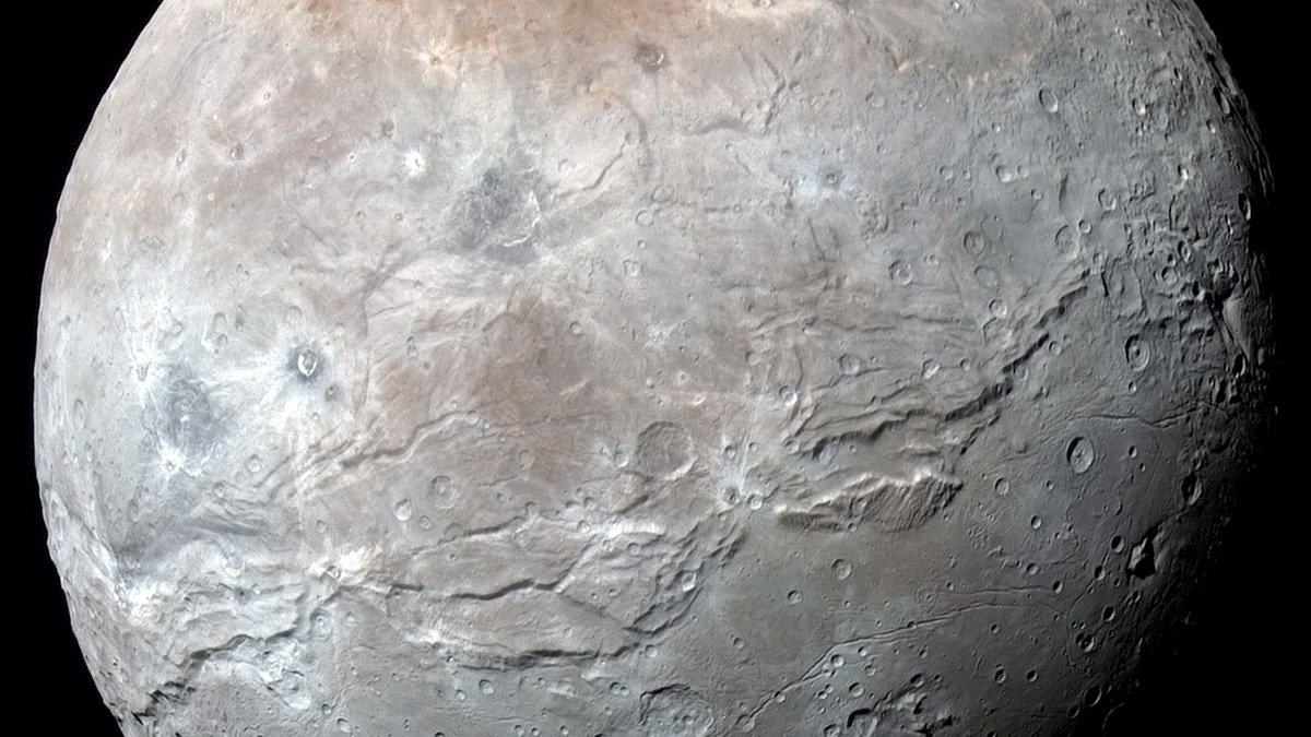 High resolution view of Pluto's moon Charon showing vast canyons and cratered icy terrain