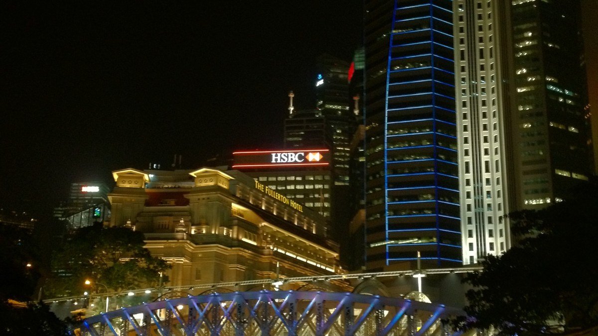 Formula 1 car speeding under night floodlights along Marina Bay street circuit in Singapore