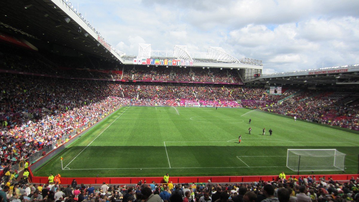 Old Trafford football stadium at night under Europa League floodlights