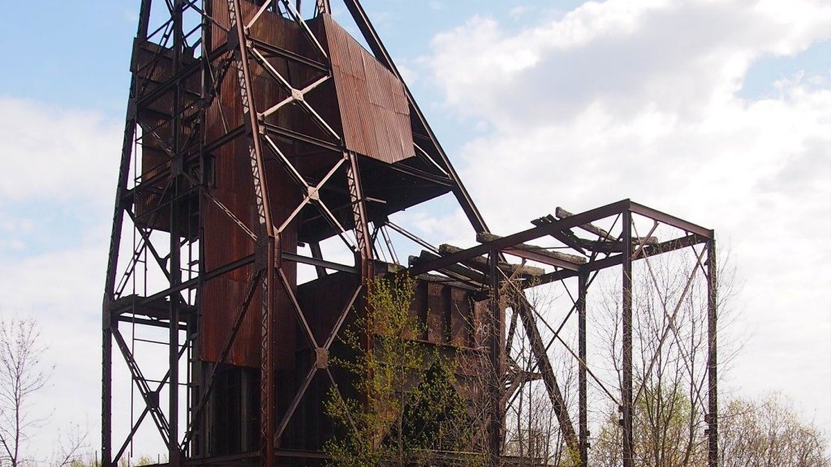 Industrial headframe and pithead of an underground coal mine against desert mountains