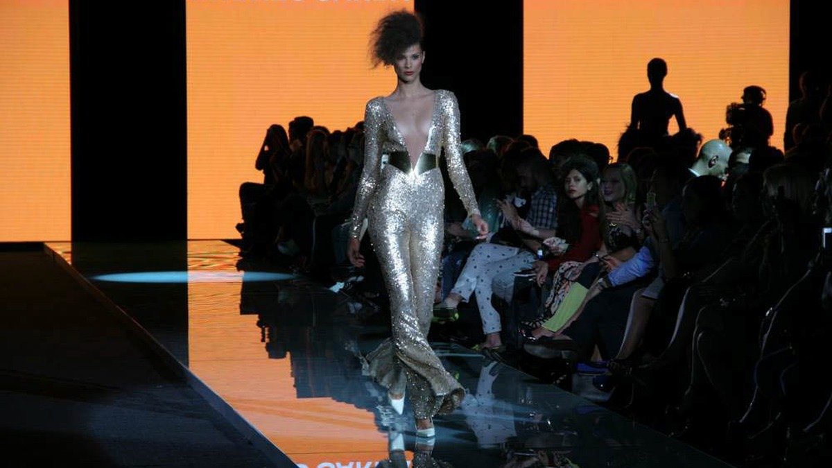 Fashion runway stage with elegant models showcasing tailored haute couture under spotlights