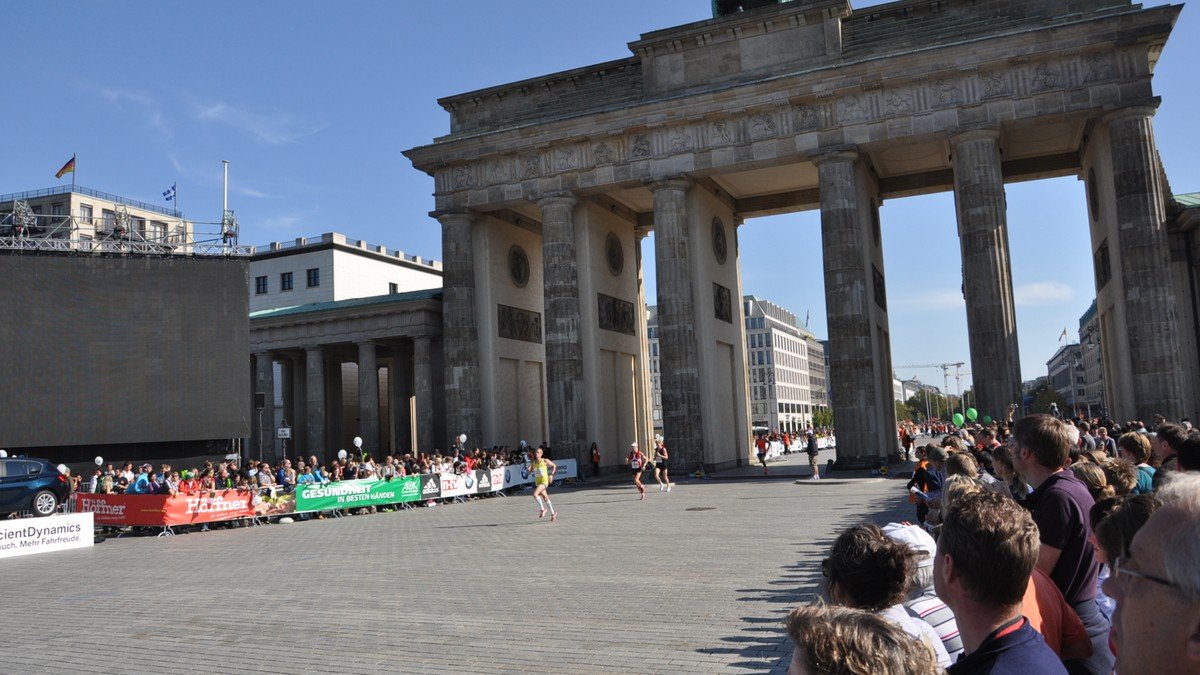 Runners crossing through the iconic Brandenburg Gate during the landmark Berlin Marathon