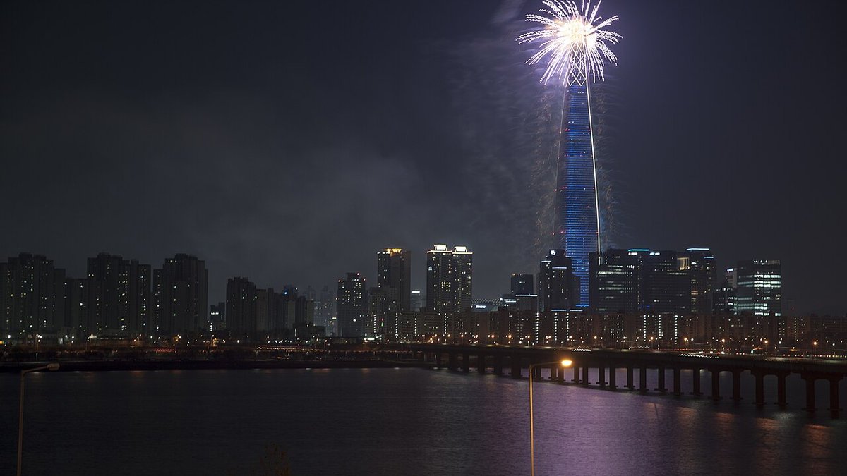 Brilliant fireworks illuminate the night sky and reflect on the Han River near Yeouido in Seoul