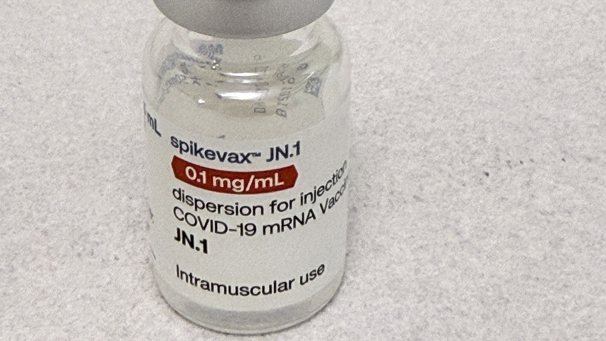 Healthcare worker holding vaccine vials in protective clinical laboratory environment