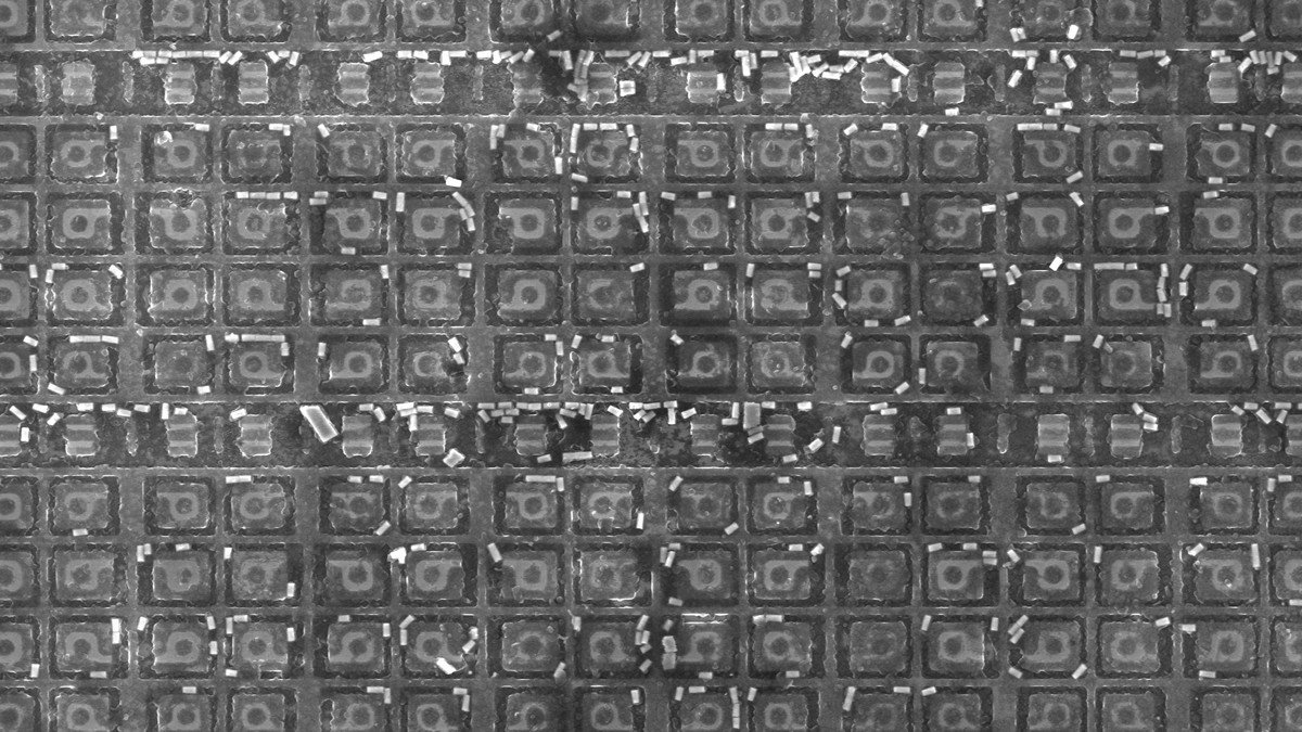 Close-up of an SK Hynix 12-layer 36GB HBM3E memory package held with tweezers in a semiconductor laboratory
