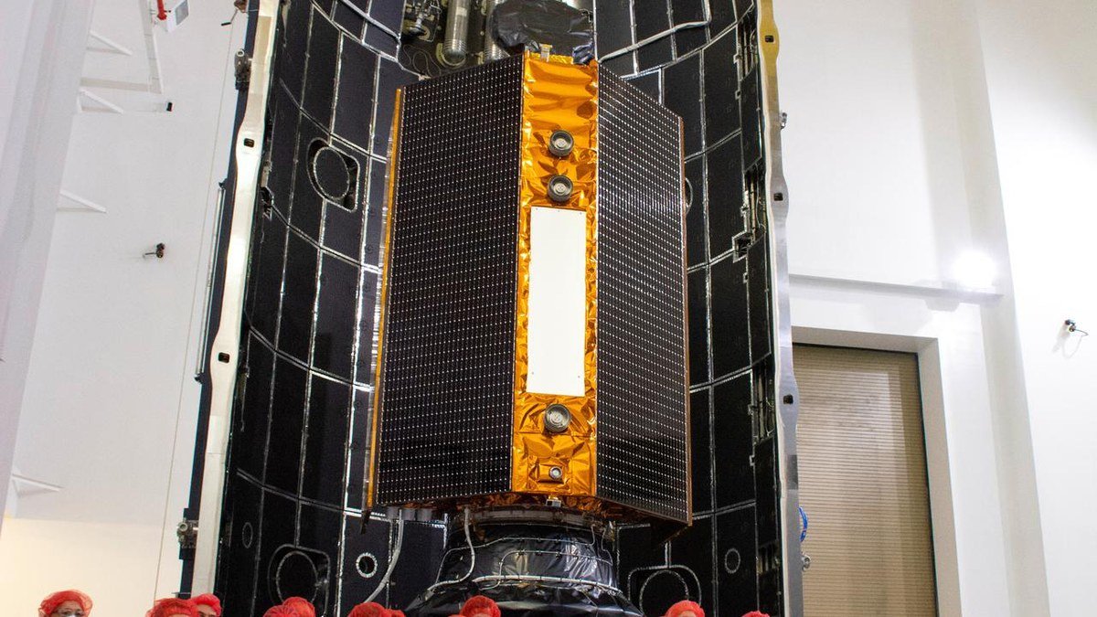 Ingenieros aeroespaciales emiratíes inspeccionando el satélite de observación terrestre MBZ-SAT en una sala limpia del Centro Espacial Mohammed Bin Rashid en Dubái