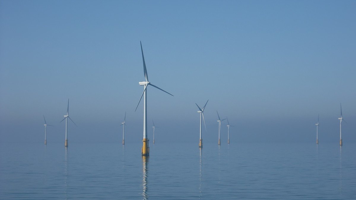 Offshore wind turbines standing in coastal British waters under clear sky