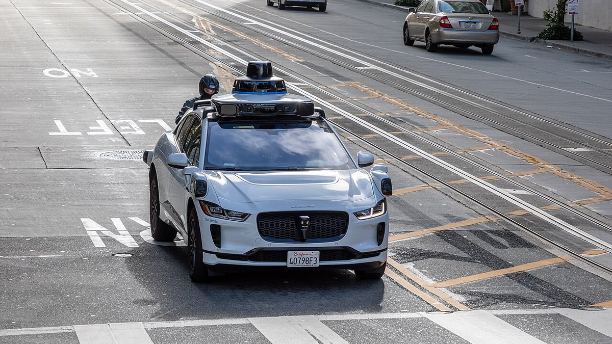 Waymo fully autonomous Jaguar I-PACE electric robotaxi driving on a city street in San Francisco